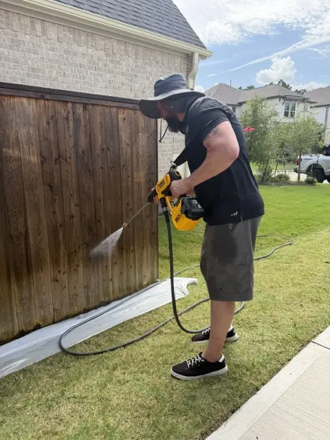 WOLF professional applying fence treatment